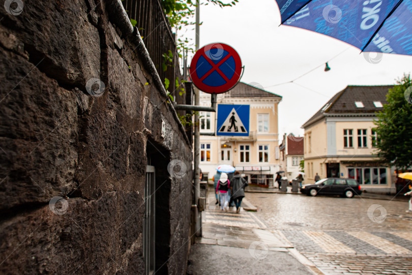 Скачать Европейская уличная сцена с пешеходами и зонтиками в дождливый день фотосток Ozero