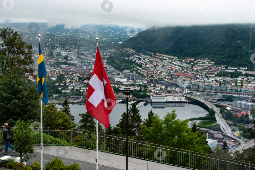 Скачать Живописный вид Бергена со шведским и швейцарским флагами на переднем плане фотосток Ozero