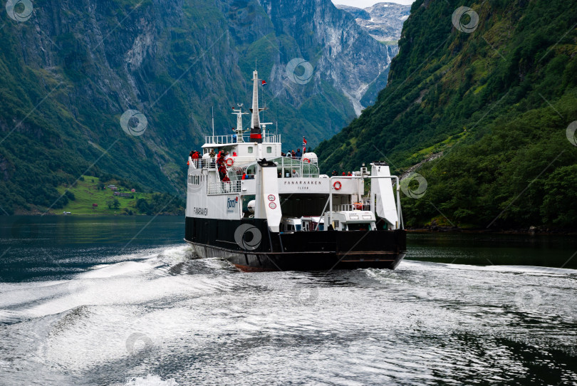 Скачать Паром, курсирующий по живописному фьорду на фоне величественных гор в Норвегии фотосток Ozero
