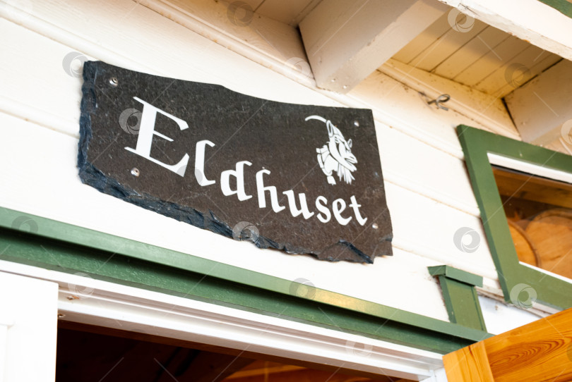 Скачать Деревенская вывеска снаружи скандинавского деревянного дома с эмблемой козла фотосток Ozero