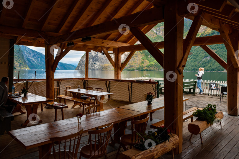 Скачать Живописное деревянное кафе на берегу реки с видом на горы и озеро фотосток Ozero