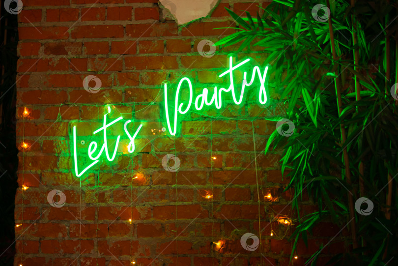 Скачать Неоновая вывеска на стене с надписью "Давай веселиться" фотосток Ozero