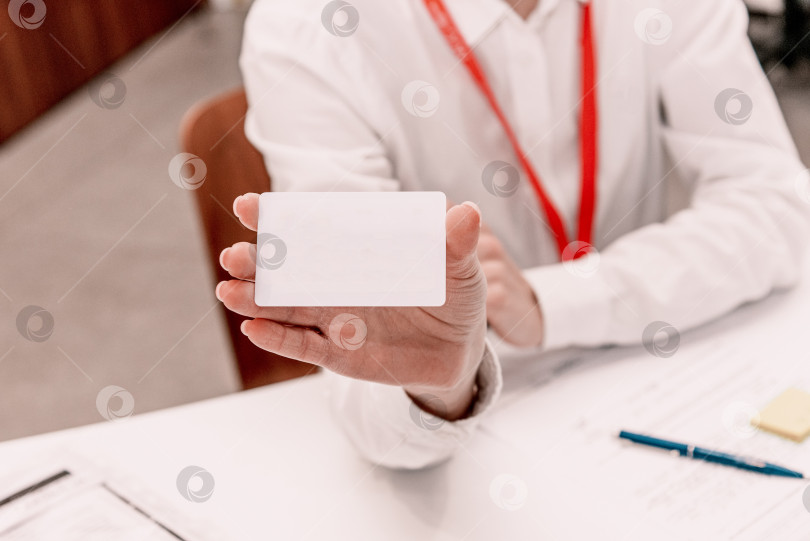 Скачать Бизнесвумен держит в руке белую визитку с макетом места для текстовой информации фотосток Ozero
