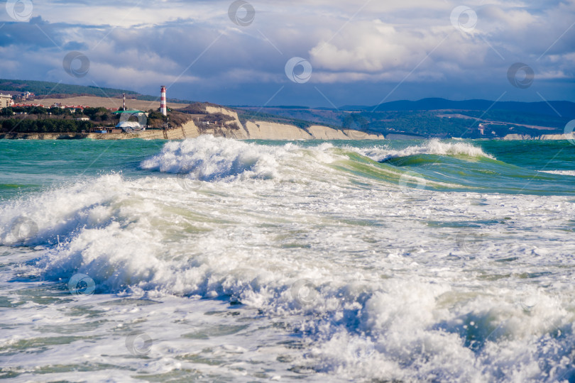 Скачать Курорт Геленджик. Большие зеленые штормовые волны накатывают на фоне Геленджикского маяка. Маяк стоит на высоком утесе фотосток Ozero