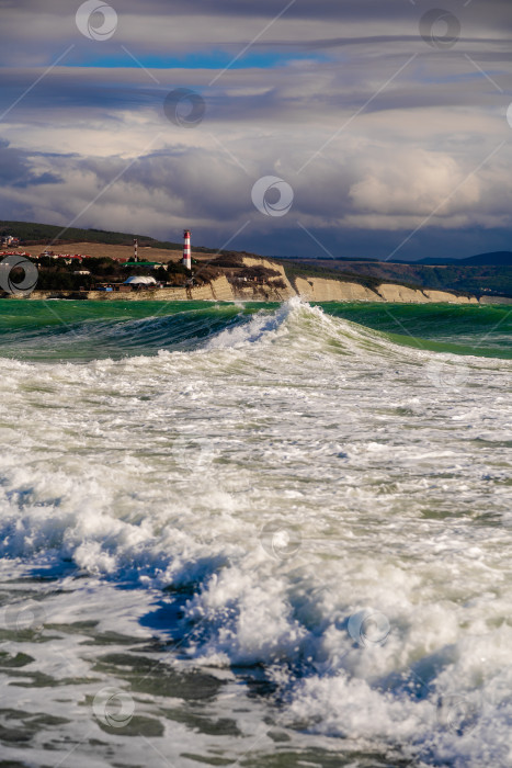 Скачать Курорт Геленджик. Большие зеленые штормовые волны накатывают на фоне Геленджикского маяка. Маяк стоит на высоком утесе фотосток Ozero