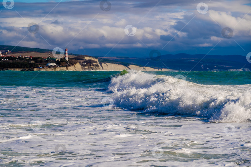Скачать Курорт Геленджик. Большие зеленые штормовые волны накатывают на фоне Геленджикского маяка. Маяк стоит на высоком утесе фотосток Ozero