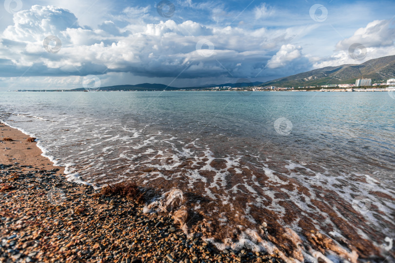 Скачать Курорт Геленджик. Пляж со скалистой береговой линией и облачным небом фотосток Ozero
