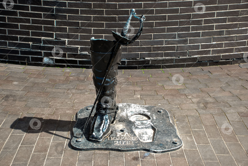 Скачать Статуя в металлическом сапоге и с мечом и надписью на кирпичной дорожке фотосток Ozero