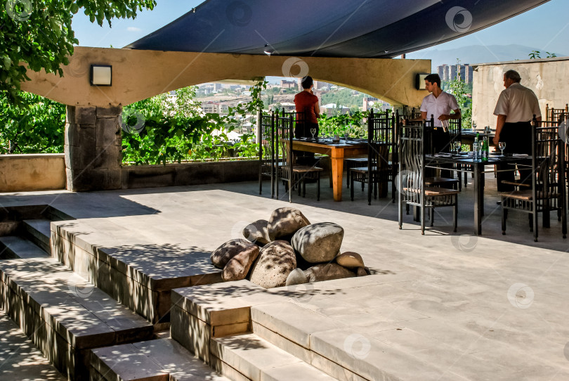 Скачать Обед на открытой террасе с двумя взрослыми белыми мужчинами, накрывающими стол фотосток Ozero