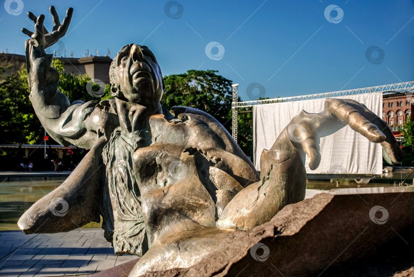 Скачать Впечатляющая бронзовая скульптура борющегося человека, поднимающегося из воды фотосток Ozero