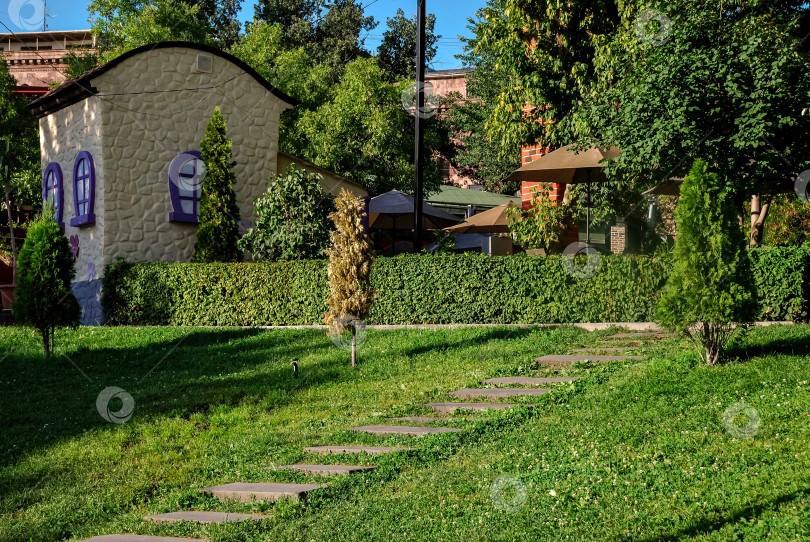 Скачать Очаровательный каменный коттедж в пышном саду с живой изгородью и дорожкой фотосток Ozero