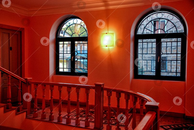 Скачать Элегантная лестничная площадка с теплым освещением и арочными окнами фотосток Ozero