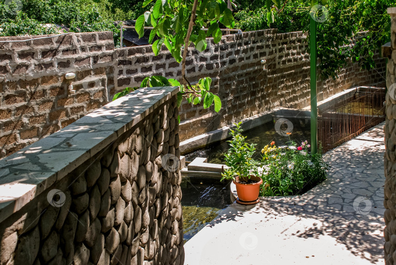 Скачать Тихая садовая дорожка с каменными стенами и проточной водой фотосток Ozero