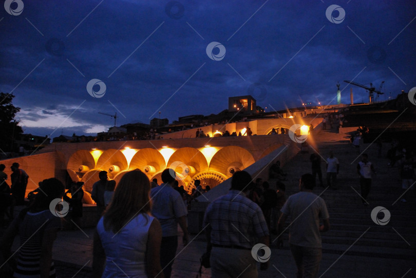 Скачать Ночные посиделки на освещенных городских ступенях под пасмурным небом фотосток Ozero