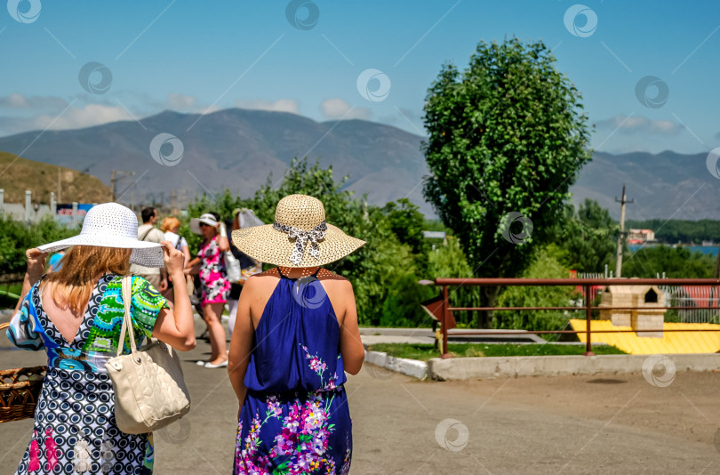 Скачать Кавказские женщины в летних платьях и шляпках наслаждаются живописным видом на горы фотосток Ozero