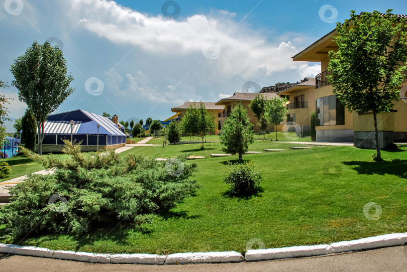 Скачать Современный жилой комплекс с зеленью и голубым небом фотосток Ozero