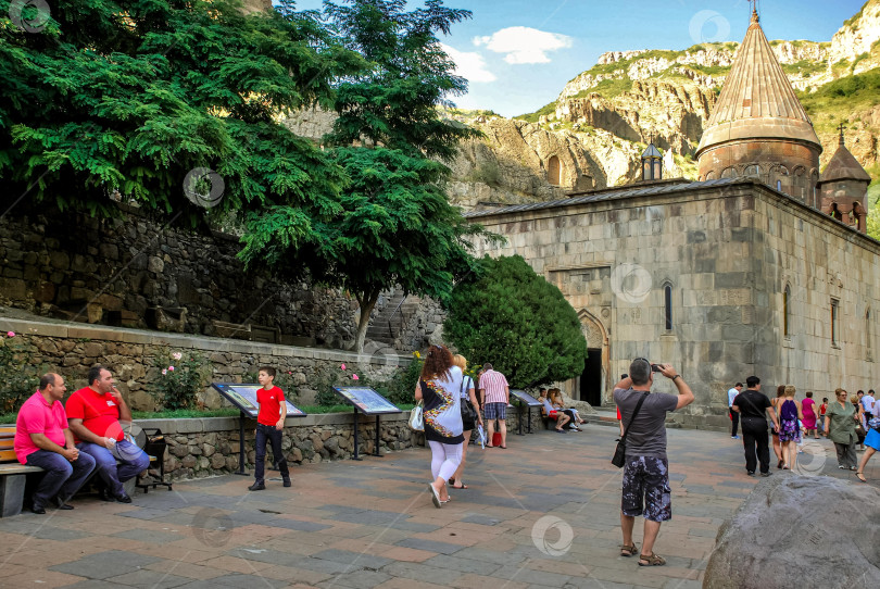 Скачать Туристы осматривают исторический монастырский двор с живописным видом на горы фотосток Ozero