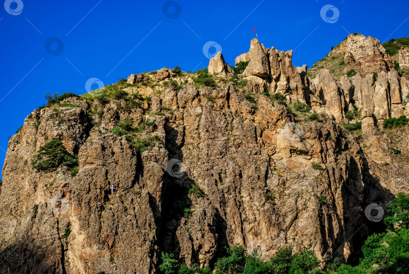 Скачать Возвышающиеся утесы со скалистыми вершинами под ясным голубым небом фотосток Ozero