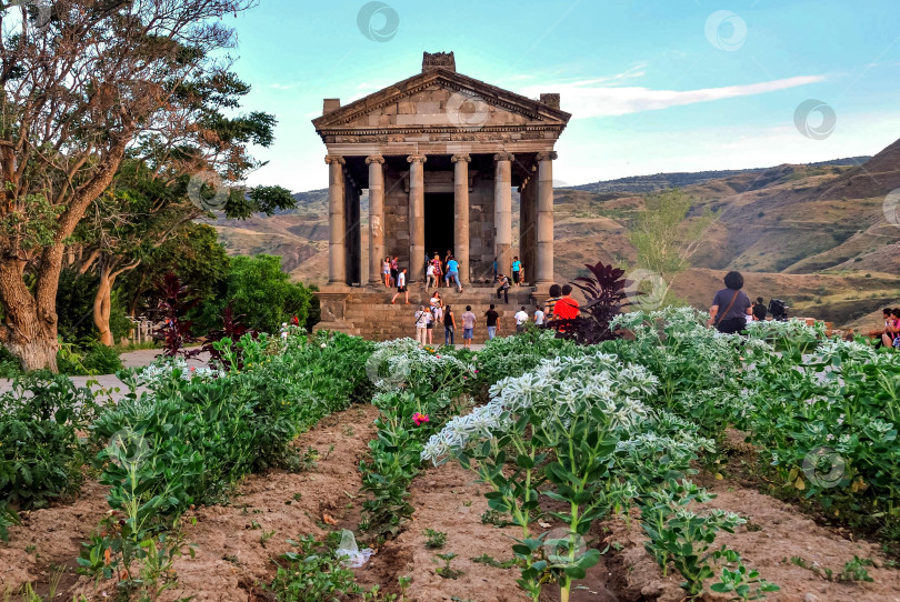 Скачать Древний языческий храм в Гарни с туристами и ярким садом в Армении фотосток Ozero