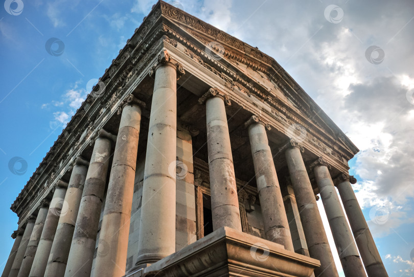 Скачать Древний храм с коринфскими колоннами на фоне голубого неба и облачности фотосток Ozero