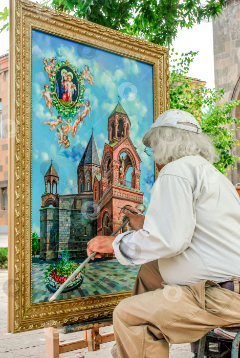 Скачать Пожилой художник-мужчина рисует религиозную архитектурную сцену на открытом воздухе при ярком дневном свете фотосток Ozero