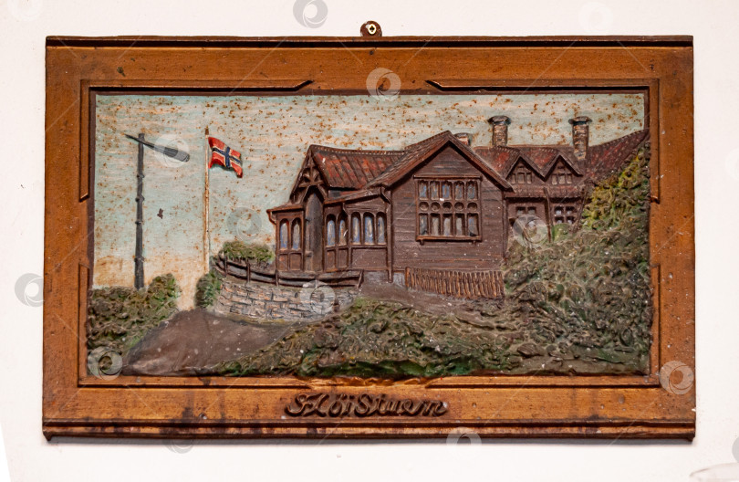 Скачать Старинный норвежский деревянный дом с рельефом на фоне флага и деревенского пейзажа фотосток Ozero