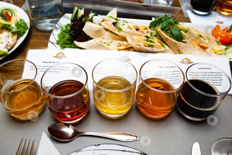 Скачать Разнообразные сорта крафтового пива подаются к закускам на обеденном столе фотосток Ozero