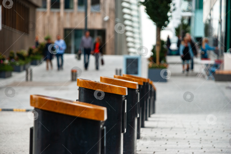 Скачать Городская уличная сцена с деревянными скамейками и гуляющими по центру города людьми фотосток Ozero