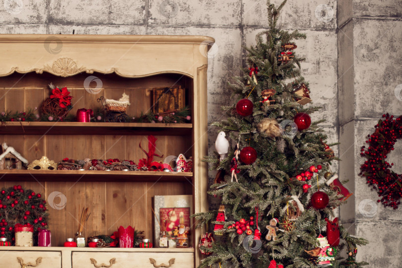 Скачать Рождественская елка с шарами и игрушками стоит рядом со старым шкафом. фотосток Ozero