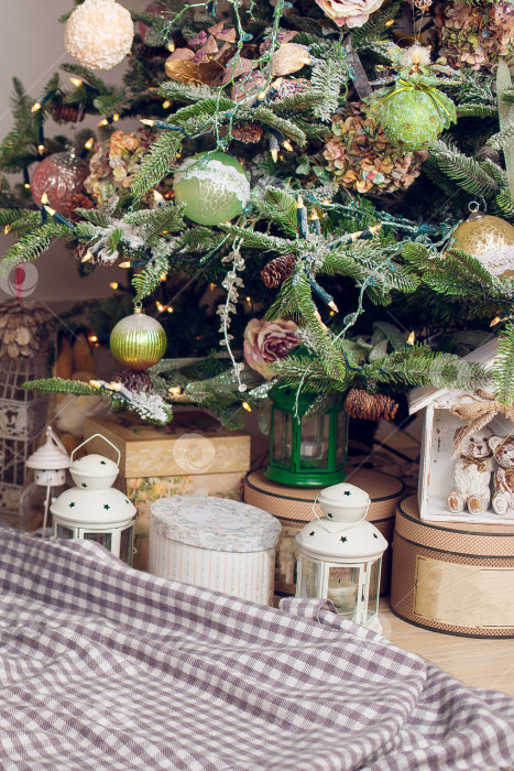 Скачать Подарки лежат на клетчатом одеяле под рождественской елкой. фотосток Ozero