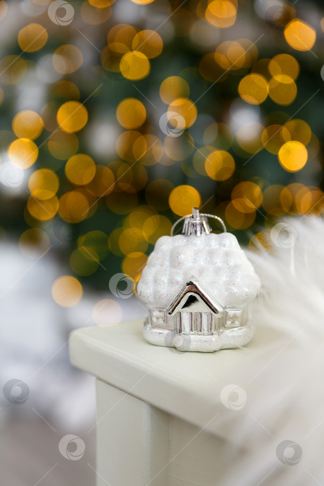 Скачать Рождественский стеклянный игрушечный домик на фоне желтых огоньков гирлянд фотосток Ozero