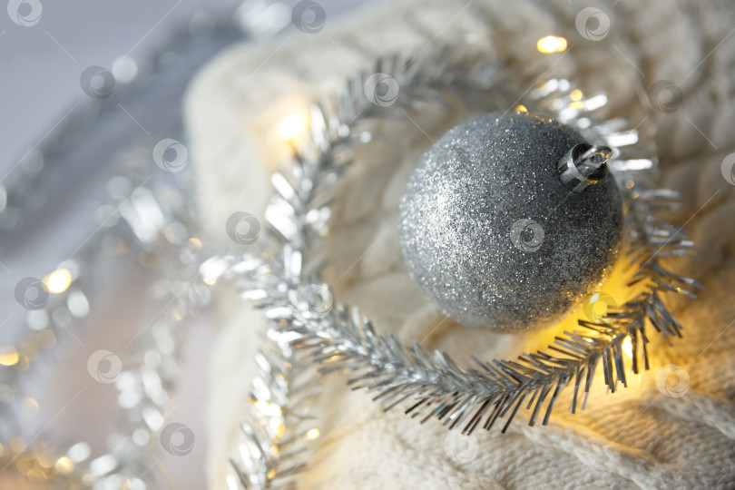 Скачать Рождество. Рождественский игрушечный шар и гирлянда на вязаном свитере. фотосток Ozero