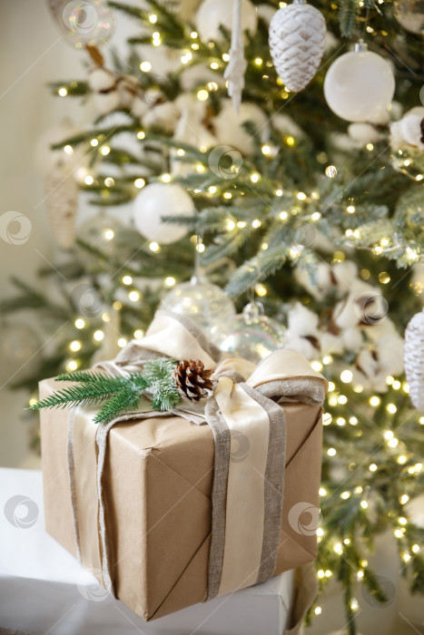 Скачать Подарок в коробке на фоне горящей новогодней гирлянды и новогодней елки фотосток Ozero