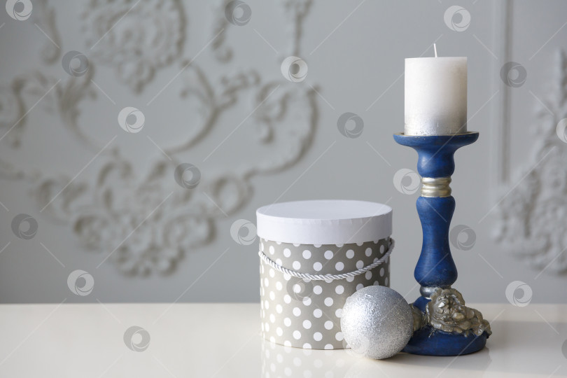 Скачать Рождественская открытка. Свеча в синем подсвечнике на белом фоне. Новогодний фон. Место для текста и сообщения фотосток Ozero