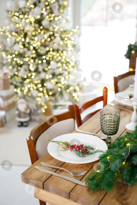 Скачать Сервировка стола с использованием посуды. Праздничное оформление еловыми ветками и гирляндами фотосток Ozero