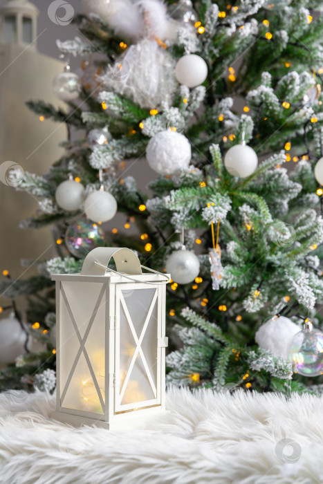 Скачать белый фонарь на меховой подкладке, на фоне горящих елочных гирлянд. Новогодняя или рождественская открытка фотосток Ozero