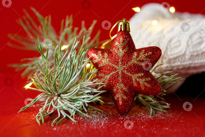 Скачать Рождественская игрушка и еловая ветка на фоне вязаного свитера и гирлянды фотосток Ozero