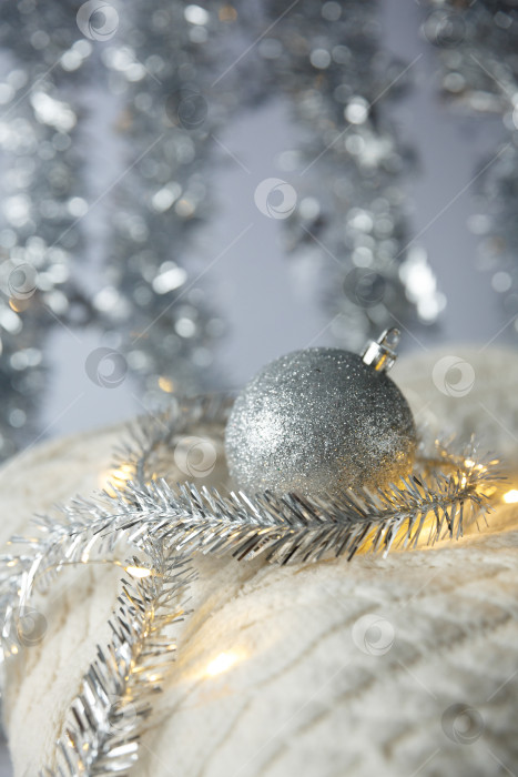 Скачать Рождество. Рождественский игрушечный шар и гирлянда на вязаном свитере. фотосток Ozero