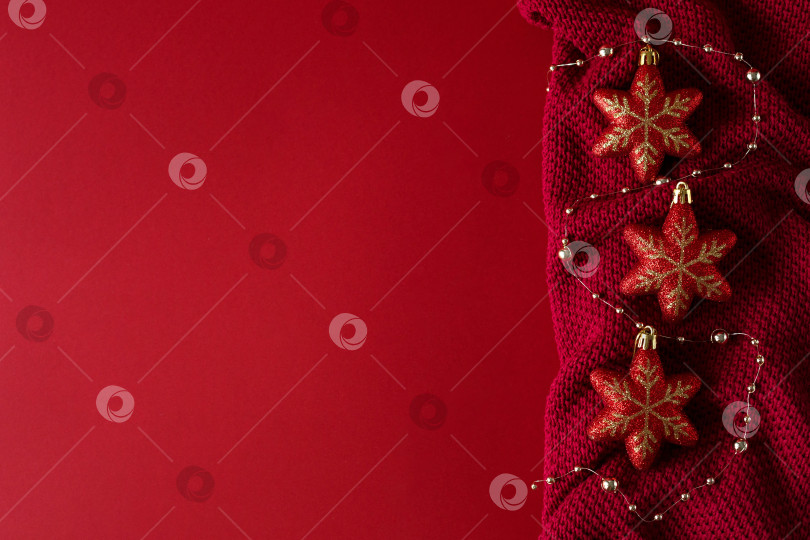 Скачать Красный рождественский фон с красными рождественскими игрушками на красном трикотажном полотне фотосток Ozero