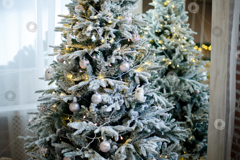Скачать Белоснежная пушистая елка, украшенная белыми игрушками и гирляндами фотосток Ozero