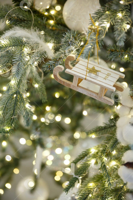Скачать Новогодние игрушечные санки висят на ветке ели фотосток Ozero