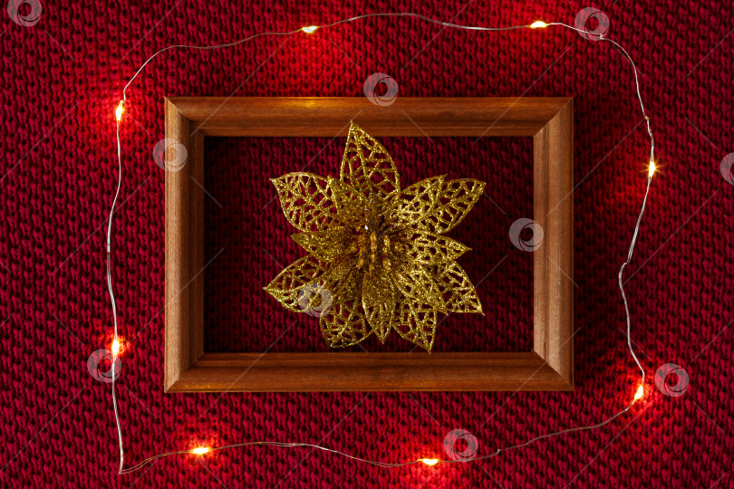 Скачать Рождественский фон. Рождественские игрушки, рамка и гирлянда на трикотажной основе свитера. фотосток Ozero