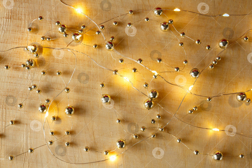 Скачать Рождественский фон. Бусы и гирлянда на светлом деревянном фоне фотосток Ozero