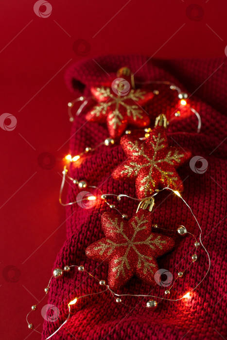 Скачать Рождественский фон с елочными игрушками, бусинами и гирляндой на трикотажном полотне. фотосток Ozero