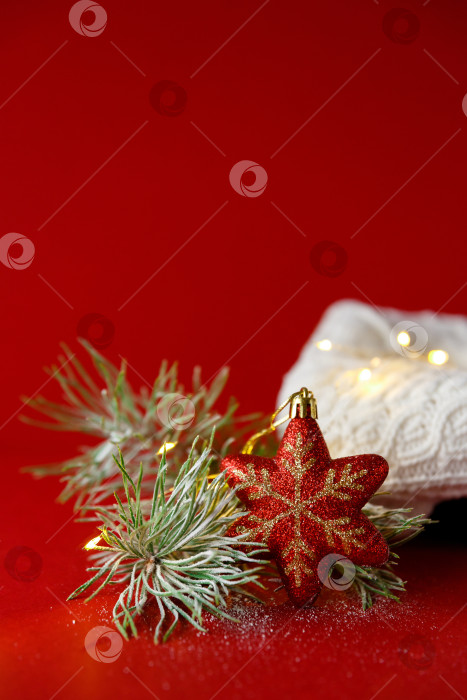 Скачать Рождественская игрушка и еловая ветка на фоне вязаного свитера и гирлянды фотосток Ozero