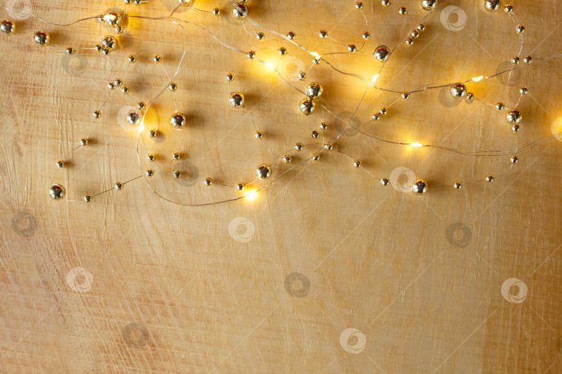 Скачать Рождественский фон. Бусы и гирлянда на светлом деревянном фоне фотосток Ozero