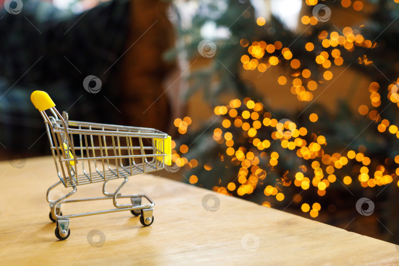 Скачать тележка с продуктами на столе на фоне гирлянд в стиле боке фотосток Ozero