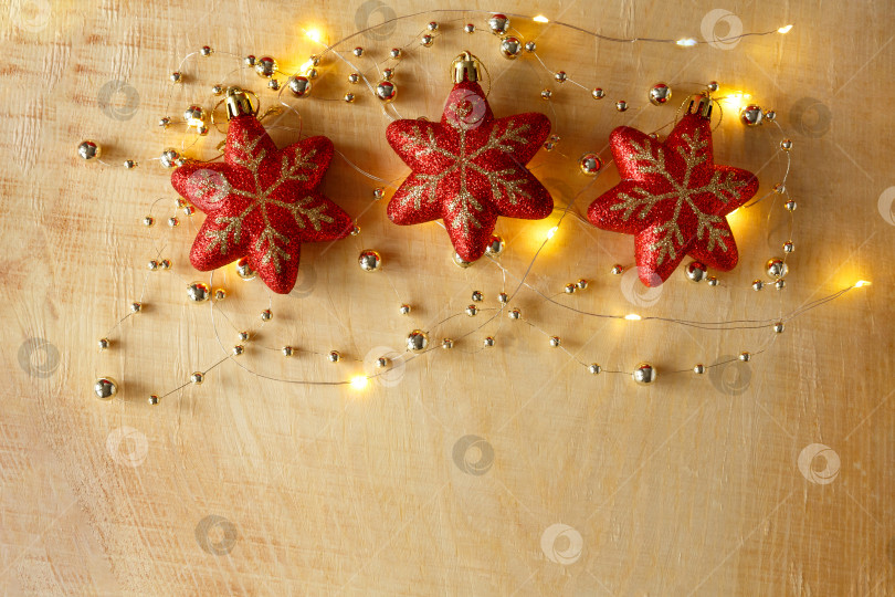 Скачать Рождественский фон. Бусы, гирлянды и игрушки на светлом деревянном фоне фотосток Ozero
