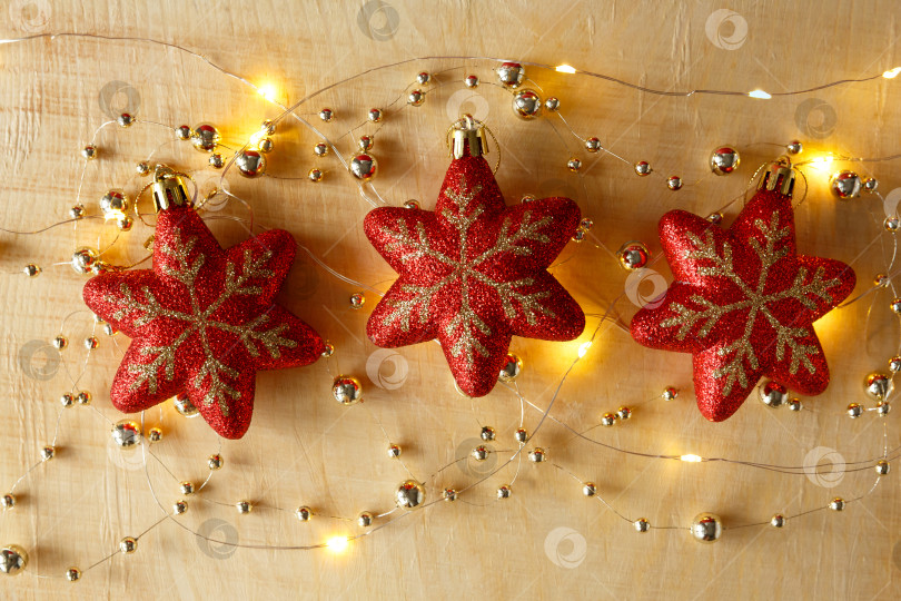 Скачать Рождественский фон. Бусы, гирлянды и игрушки на светлом деревянном фоне фотосток Ozero