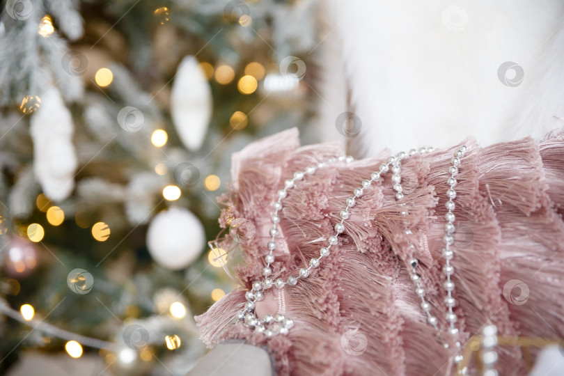 Скачать Бусины лежат на пушистом пледе на фоне рождественской елки фотосток Ozero